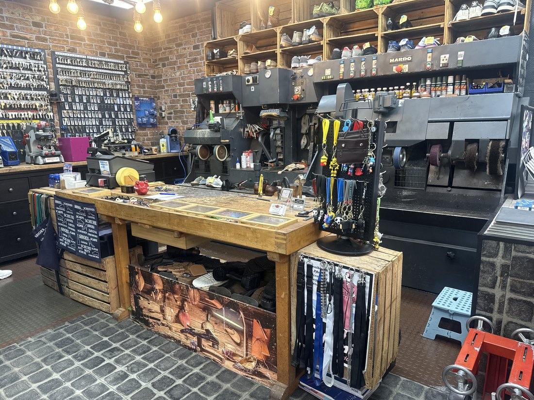 Blick in die Werkstatt mit der Schlüsselwand links, den Maschinen im Hintergrund und der großen Holzwerkbank.